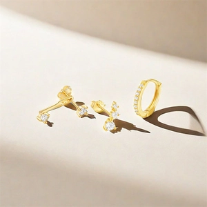 Detail of s925 silver gold-plated earring set featuring zircon studs and small pavé hoop