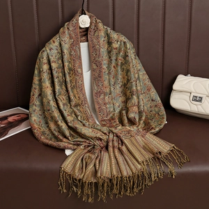 Detailed view of paisley patterns and fringes on a vintage brown cashmere-feel shawl