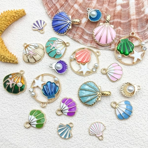 Macro shot of colorful enamel seashell charms with imitation pearls for DIY jewelry making