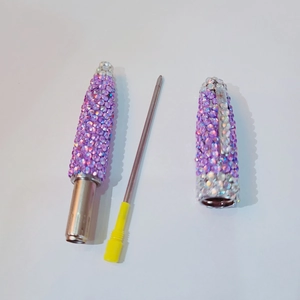 Disassembled view of purple rhinestone pen with metal body and refill components