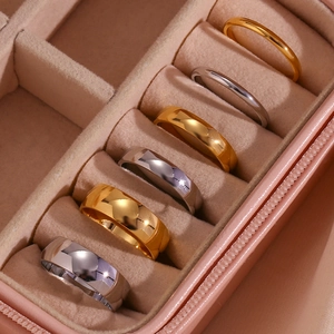 Six gold and silver minimalist metal rings displayed in a luxury pink velvet jewelry box