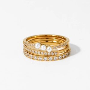 Three-piece gold-tone ring set featuring elegant pearls and sparkling rhinestones