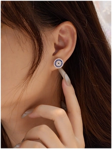 Close-up of S925 silver Evil Eye stud earrings with blue and white zircons on ear