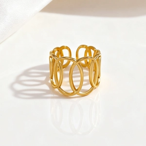 Detail of gold open ring with hollow oval overlapping design on a glossy white base