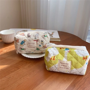 Quilted cotton organizer bags with dog and goose patterns on a wooden surface