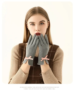 Détail de gants gris pour femmes avec un nœud rose et une texture de tissu doux