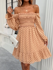 Detail of off-white polka dot dress showing off-shoulder smocked bodice and ruffles