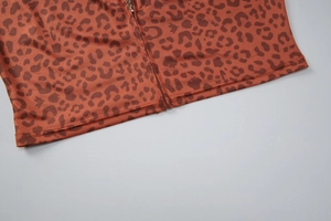 Détail de l'ourlet en tissu imprimé léopard avec fermeture éclair sur survêtement marron