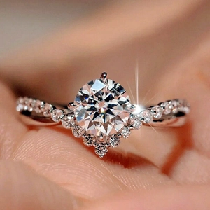 Close-up of crown-style engagement ring with a six-prong round stone on a twisted band