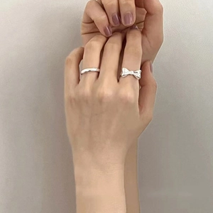 Elegant S925 sterling silver bow knot ring and minimalist band on model's hand
