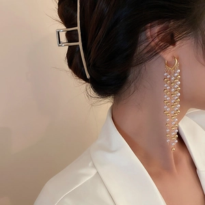 Elegant gold bead and pearl tassel earrings shown on model for a trendy fashion look