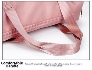 Detailed close-up of soft pink nylon webbing handles on a large travel fitness bag