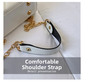 Detail of white patent leather quilted bag strap with light gold metal chain and comfort pad