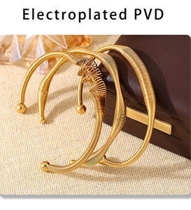 Detail of PVD electroplated gold spring wire bangles on a luxury leather jewelry box