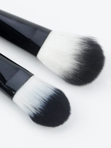 Detailed close-up of soft synthetic bristles and sleek black handles on makeup brushes