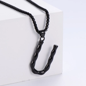 Détail du pendentif lettre U noir texture bambou sur une chaîne à perles