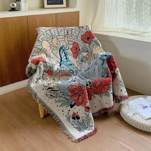 Bohemian butterfly and rose woven throw blanket with colorful fringes on a wooden chair