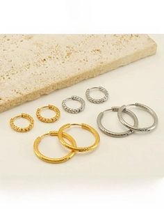 Détail de boucles d'oreilles créoles en acier titane doré et argenté torsadé