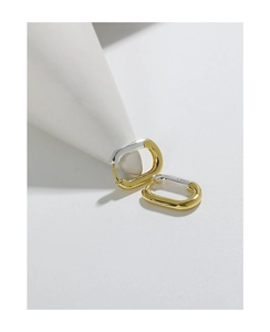 Macro detail of S925 sterling silver stamp on minimalist gold and silver oval earrings