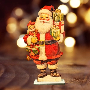 Close-up of wooden Santa Claus figurine holding a gift box with warm bokeh lighting