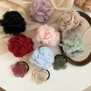 Elegante Haargummis mit Chiffon-Blumen in verschiedenen Farben auf einem Tablett