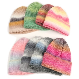 Flat lay of colorful ombre ribbed knit beanies in seven diverse gradient colorways