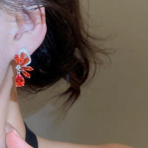 Detail of elegant red zircon butterfly earrings with silver pins and pavé stones