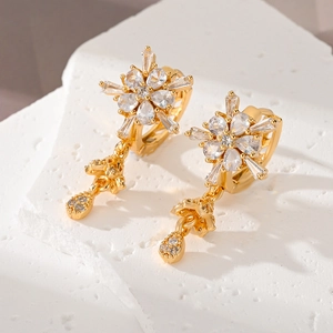 Elegant gold flower earrings with sparkling cubic zirconia and pendant on white stone