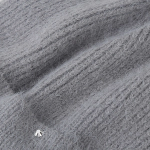 Detail of grey plush knit beanie featuring soft faux fur texture and a sparkling rhinestone