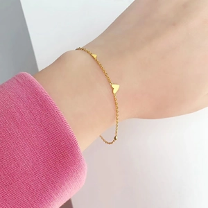 Minimalist gold heart titanium steel bracelet for women shown on a model's wrist