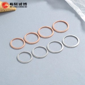 Row of silver and rose gold micro-pave rings on minimalist display stands