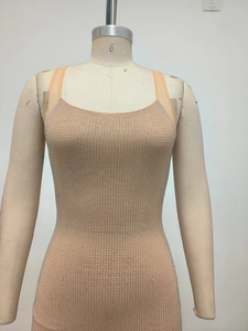 Détail d'une robe moulante nude ornée de strass brillants présentée sur un mannequin de couture