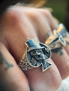 Détail d'une bague tête de mort vintage en argent avec chapeau et gravures baroques