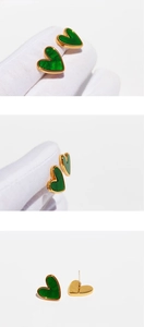 Detailed close-up of emerald green heart stud earrings with golden trim craftsmanship