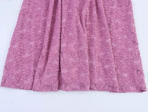 Detail shot of mauve textured floral fabric with intricate jacquard pattern for women dress