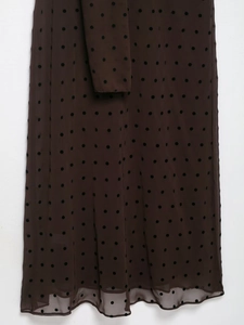 Detail of dark brown sheer mesh fabric with classic black polka dots and fine texture