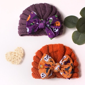 Halloween baby knit beanies in purple and orange with large festive bow patterns