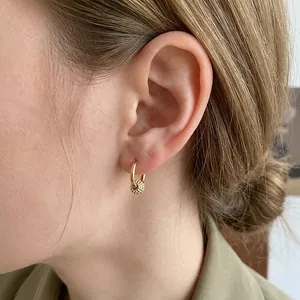 Elegant gold hoop earrings with textured beads on female model for daily style