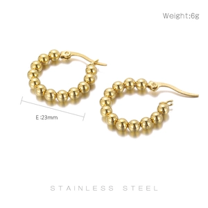 Macro detail of 23mm gold stainless steel U-shaped beaded hoop earrings with 6g weight