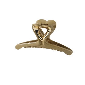 Close-up of khaki heart-shaped hair claw clip with golden metal heart detail