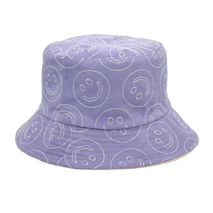 Detail of white smiley face embroidery on purple cotton canvas bucket hat fabric