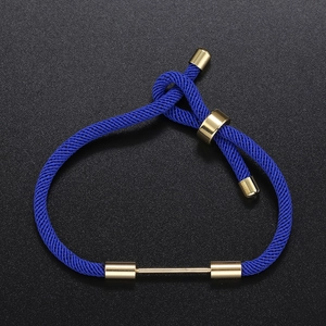Detail of adjustable dark blue braided cord bracelet with gold slide clasp and metal bar