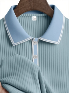 Detail of light blue knit polo shirt showing white collar stripes and textured fabric