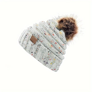 Bonnet d'hiver en tricot avec mouchetures colorées et un grand pompon en fausse fourrure