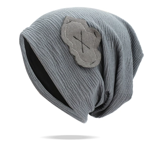 Detail shot of the wavy knit texture and cloud patch on the grey slouchy beanie hat