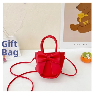 Detail shot of mini red bow crossbody bag crafted in smooth PU leather with long strap
