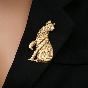 Close-up of a vintage golden cat brooch with textured metal details on a black blazer