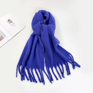 Close-up of soft blue mohair scarf fabric texture with decorative fringe detail