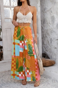 Détail du pantalon large bohème à imprimé patchwork et haut licou en crochet blanc