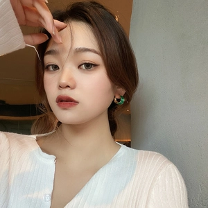 Retro C-shape green enamel hoop earrings with gold trim worn by a model in profile